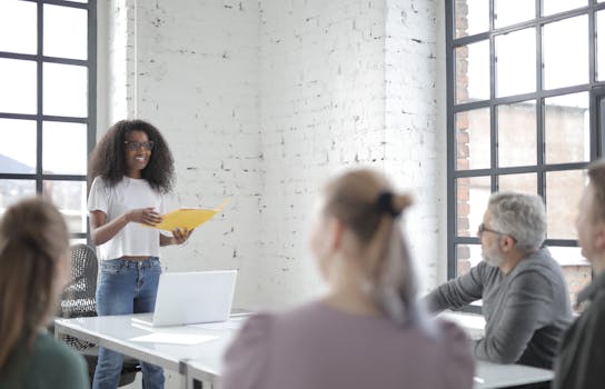 A diverse team engaged in a vibrant office meeting led by a woman presenting ideas.